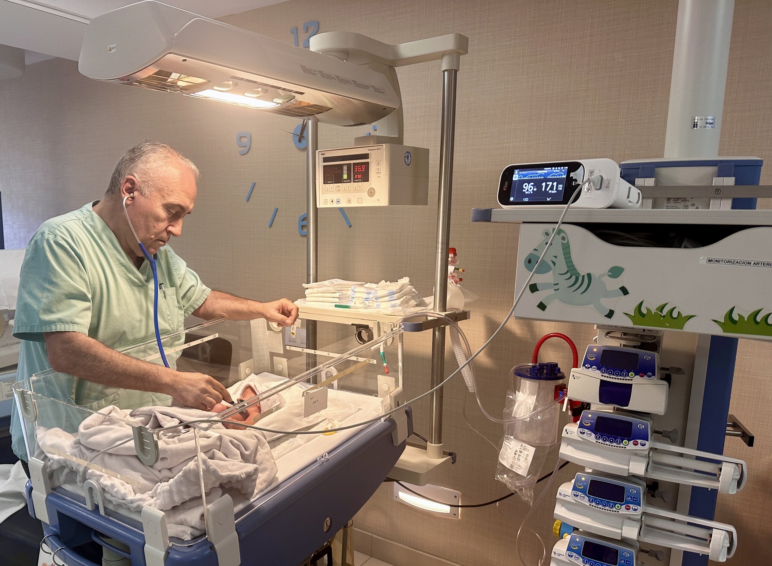 El doctor Francisco Domínguez, jefe de Pediatría del Hospital Universitario Vithas Las Palmas, ausculta a un bebé en la UCI Neonatal.