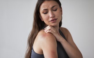 Mujer con urticaria por alergia a la penicilina Mujer mostrando urticaria en el hombro como síntoma de alergia a la penicilina